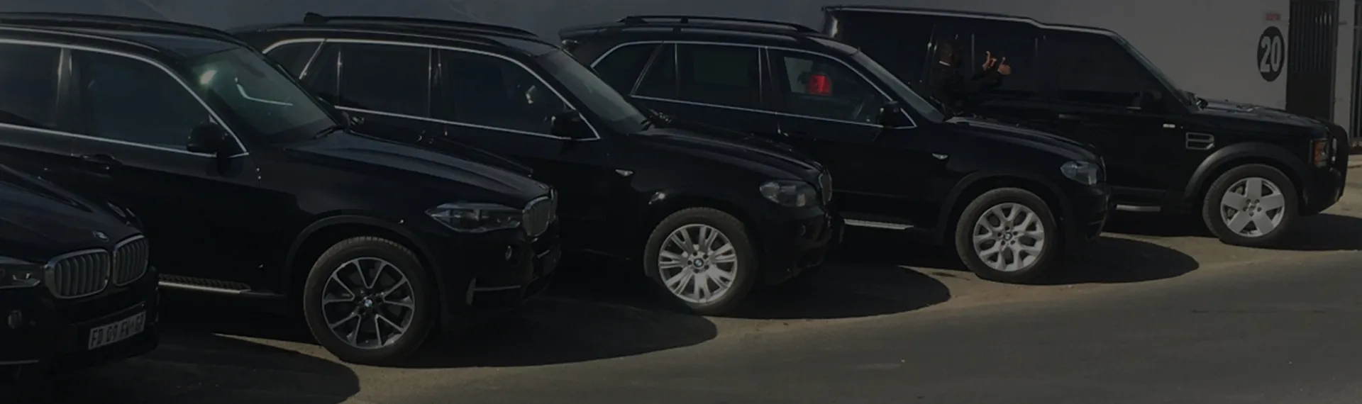 A line of black luxury SUVs parked side by side
